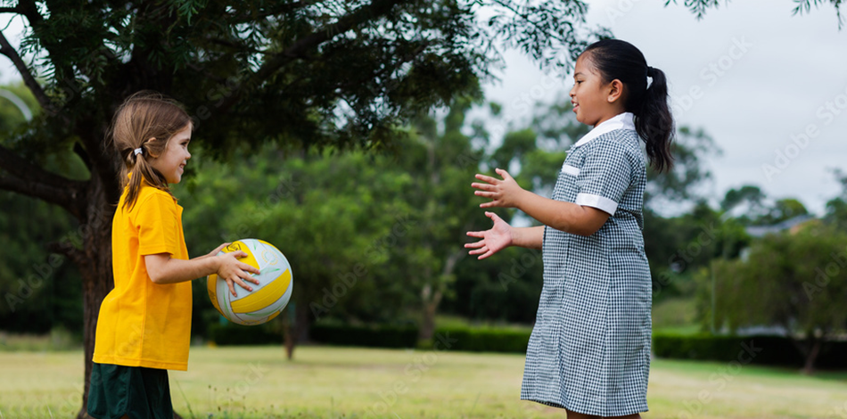 Public school girls playing a ball game outside 