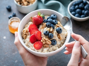 A bowl with oats, strawberries and blueberries.