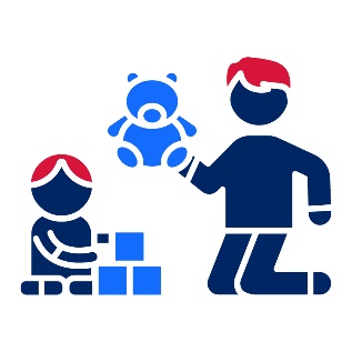 A toddler playing with blocks next to a child playing with a bear.