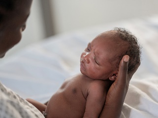 A parent holding a new-born baby.