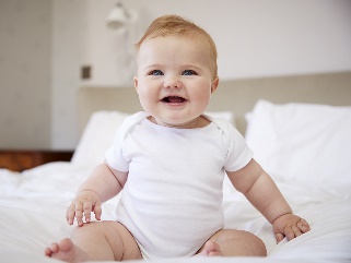A 6 month old baby sitting up.
