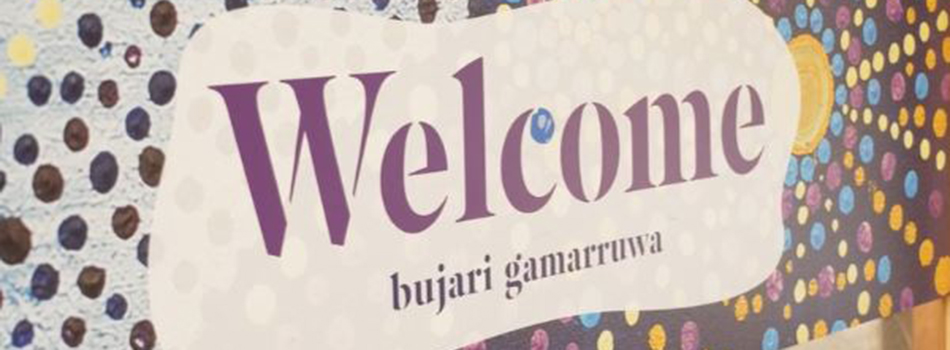 Mural sign on wall, with 'Welcome bujari gamarruwa'