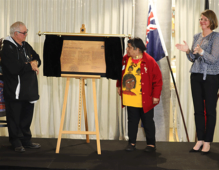 Michael ‘Widdy’ Welsh from Kinchela Boys Home and Aunty Valerie Linow from Cootamundra Girls Home unveiling a plaque. Secretary for NSW Health Susan Pearce watches.