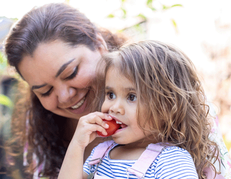 An Aboriginal woman holding a young Aboriginal girl