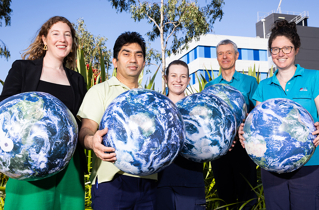 A group of NSW Health staff holding models of planet Earth