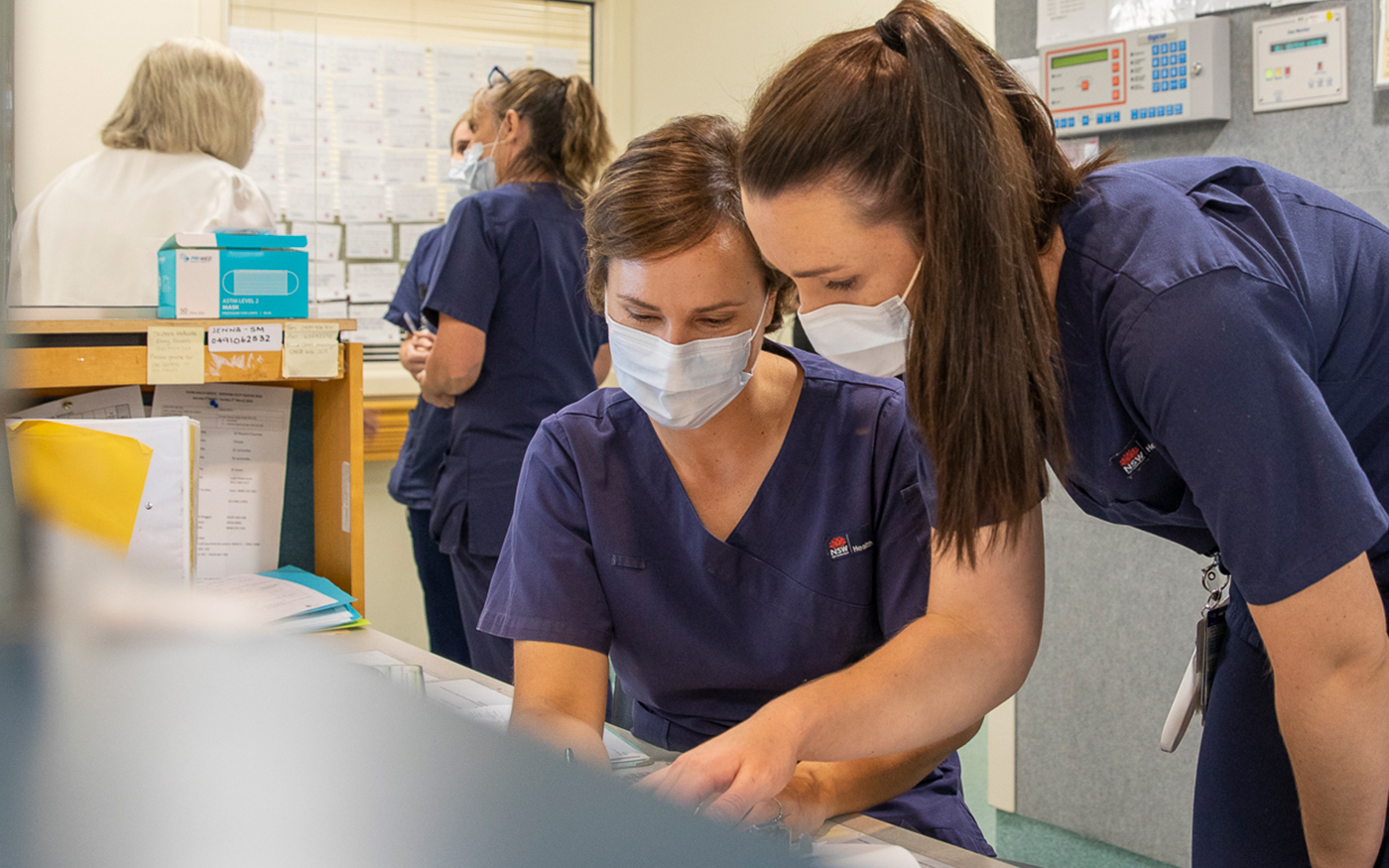 Two registered nurses reviewing notes