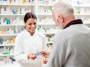 A pharmacist showing a person some medication.