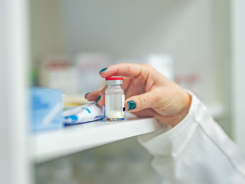 A person reaching for medication in a cupboard.