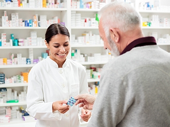 A pharmacist showing a person some medication.