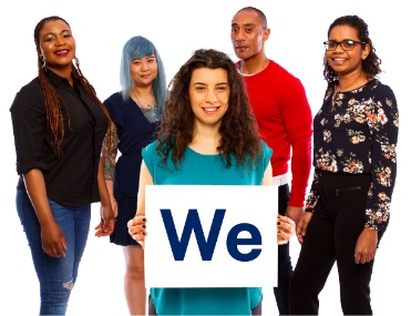 A diverse group of people. A person at the front is holding a sign that reads 'We'.