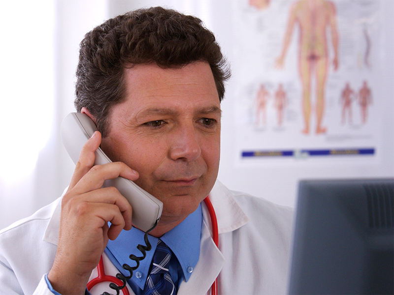 A doctor having a conversation on a phone.