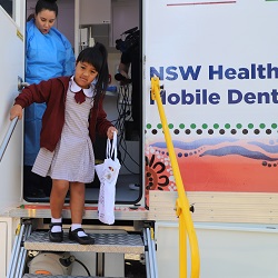 Dentist checking teeth of a school boy in a mobile dental clinic